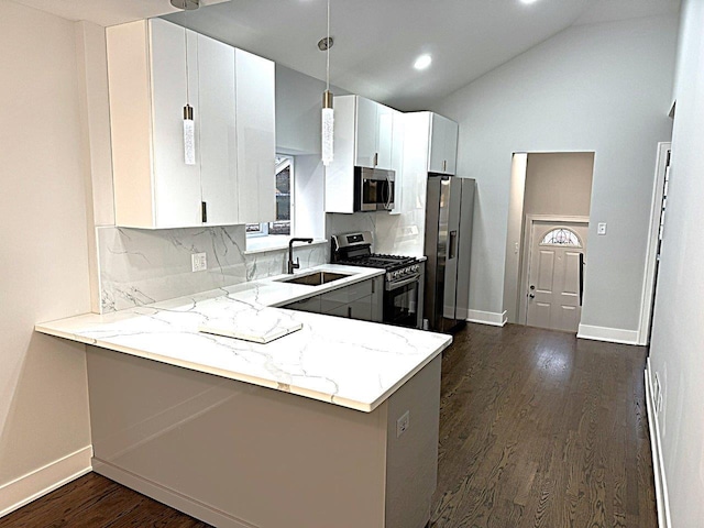 kitchen featuring appliances with stainless steel finishes, sink, white cabinets, kitchen peninsula, and light stone countertops