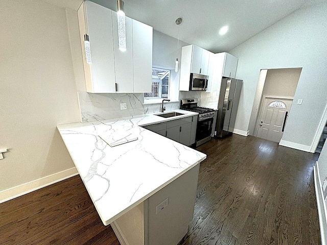 kitchen featuring sink, white cabinetry, kitchen peninsula, stainless steel appliances, and light stone countertops