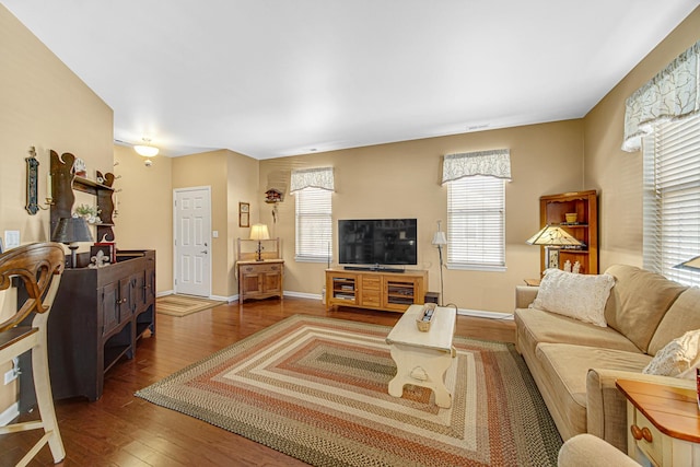 living area with baseboards, wood finished floors, and a healthy amount of sunlight