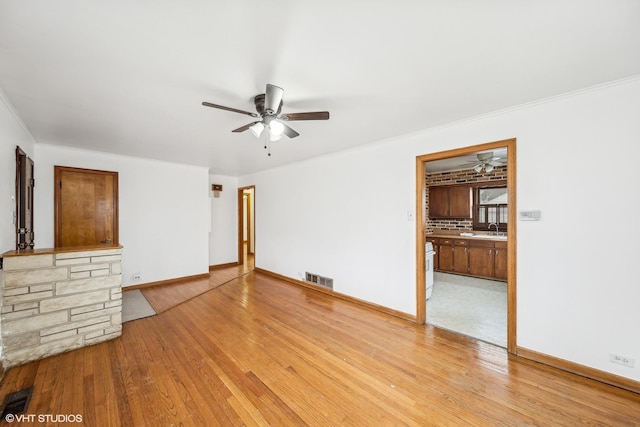 unfurnished living room featuring sink, crown molding, light hardwood / wood-style floors, and ceiling fan