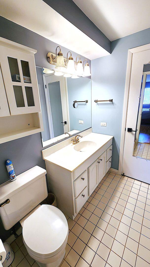 bathroom featuring vanity, tile patterned floors, and toilet