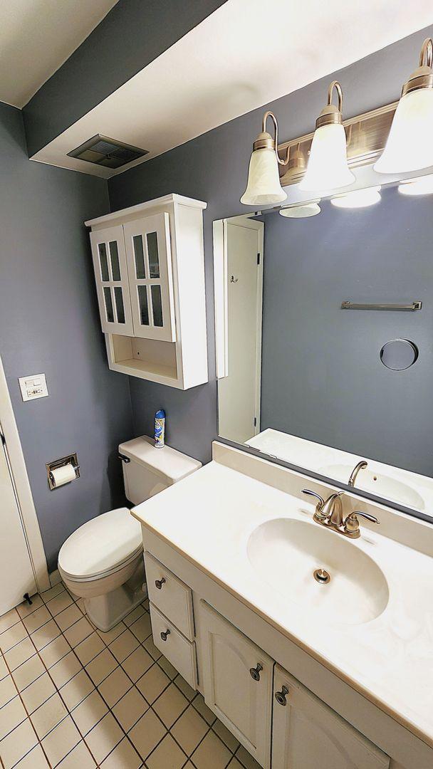 bathroom with vanity, tile patterned floors, and toilet