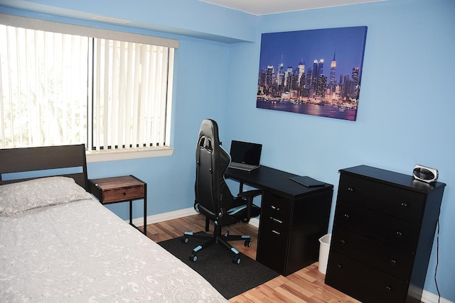 bedroom with multiple windows and hardwood / wood-style floors