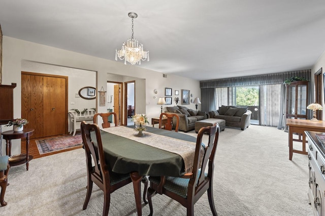 dining room featuring light carpet and an inviting chandelier