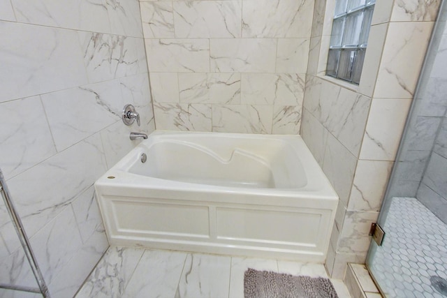 bathroom featuring tile walls and plus walk in shower