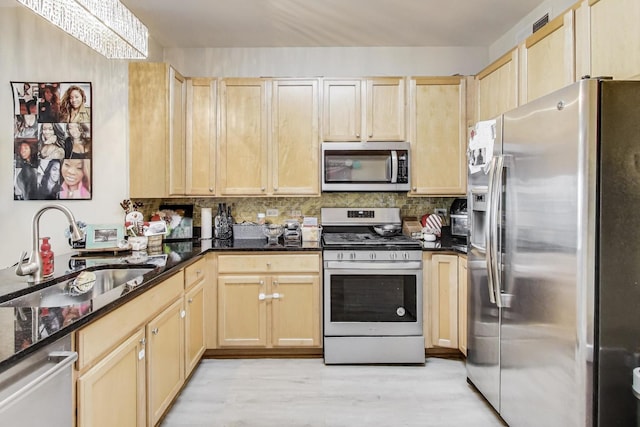 kitchen with sink, light hardwood / wood-style flooring, stainless steel appliances, light brown cabinetry, and dark stone counters