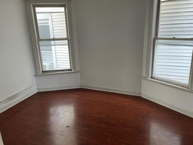 empty room with dark hardwood / wood-style flooring