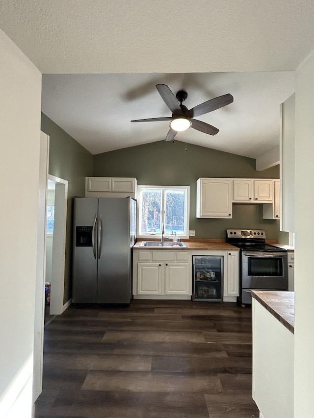 kitchen with appliances with stainless steel finishes, dark hardwood / wood-style floors, white cabinetry, sink, and beverage cooler