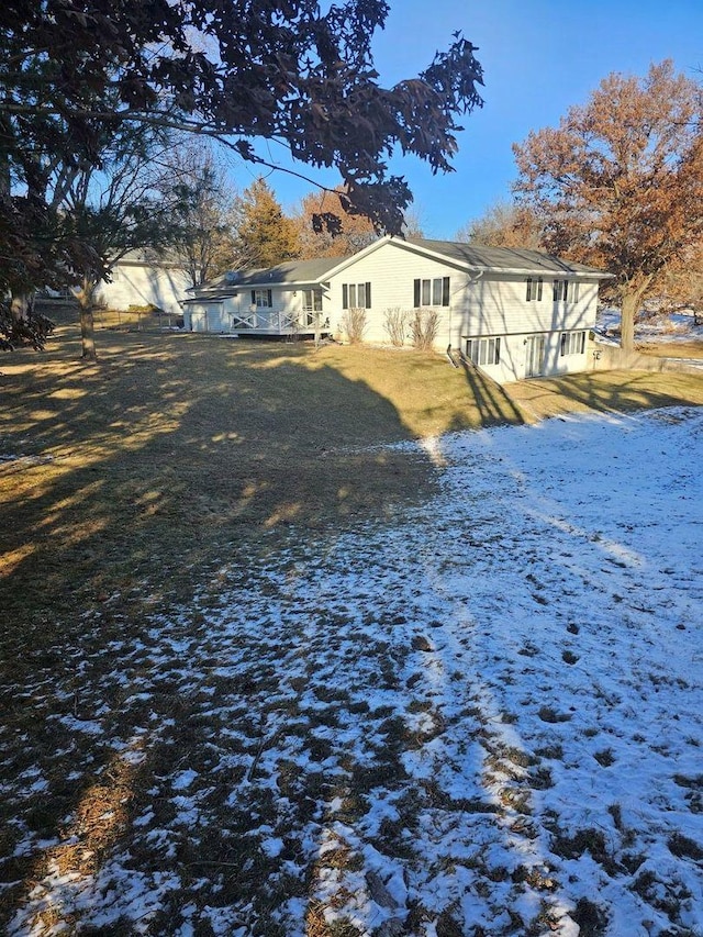 snow covered house featuring a lawn