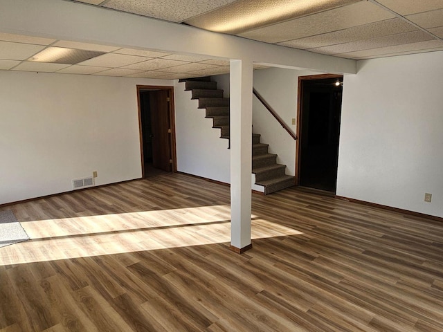 basement featuring wood-type flooring and a paneled ceiling