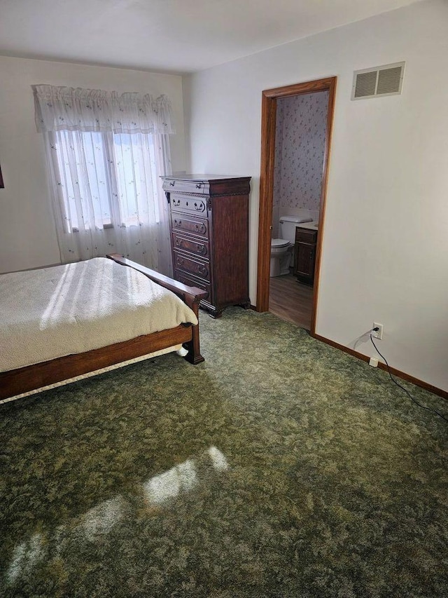 unfurnished bedroom featuring ensuite bathroom and carpet flooring