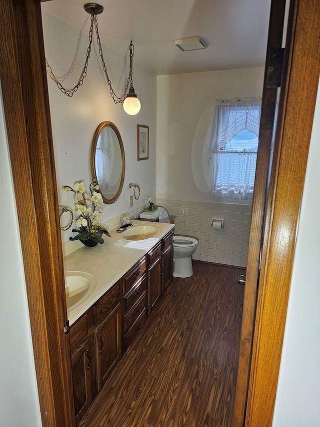 bathroom with vanity, toilet, hardwood / wood-style floors, and tile walls