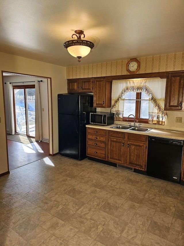 kitchen with sink, black appliances, and a healthy amount of sunlight