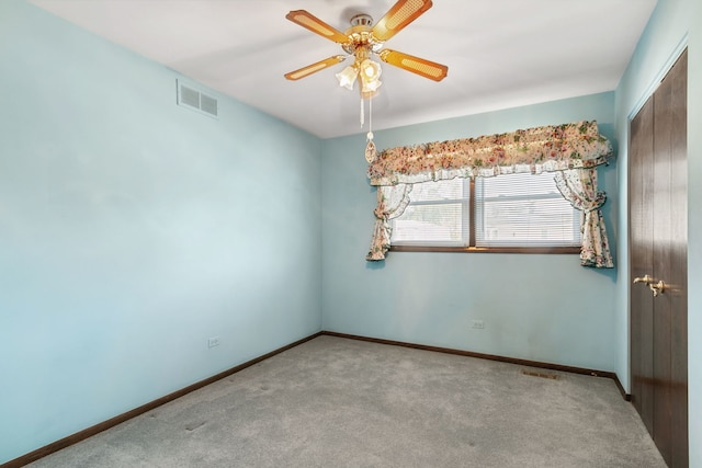 carpeted spare room with ceiling fan