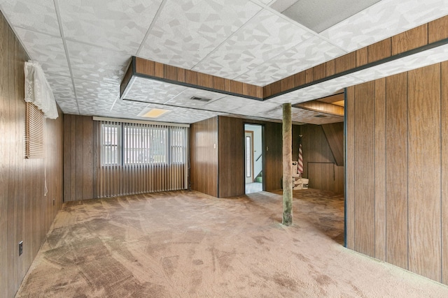 carpeted spare room with wooden walls