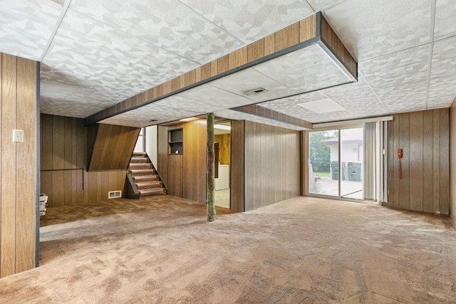 interior space featuring wooden walls and carpet