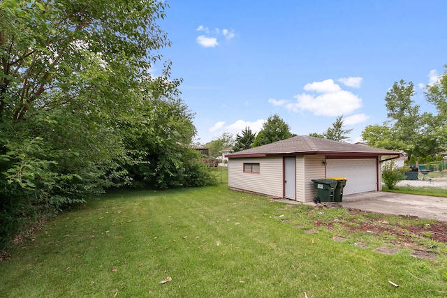 view of yard with a garage and an outbuilding