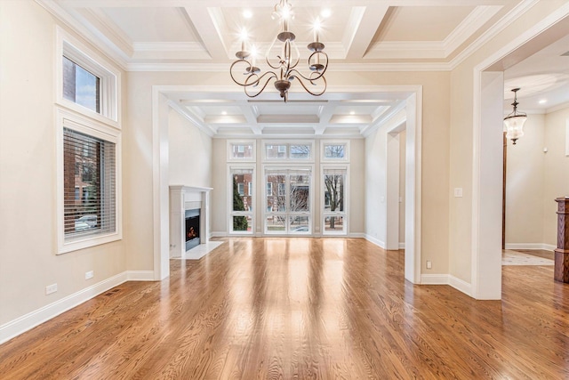 unfurnished living room featuring hardwood / wood-style flooring, plenty of natural light, and a notable chandelier