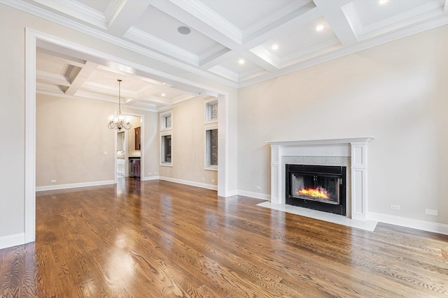 unfurnished living room with coffered ceiling, crown molding, a notable chandelier, beam ceiling, and hardwood / wood-style floors