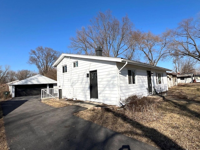 exterior space with a chimney and a detached garage