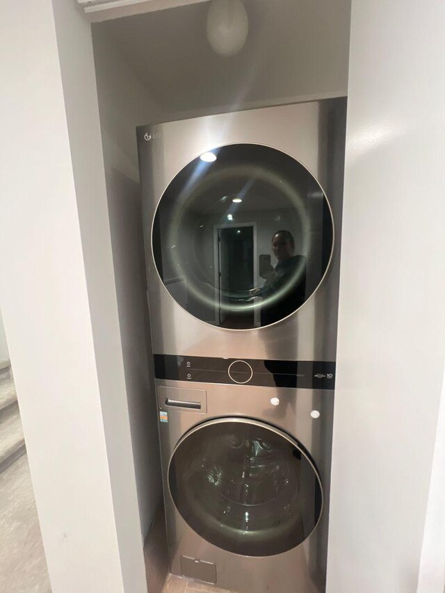 laundry room featuring stacked washer / drying machine