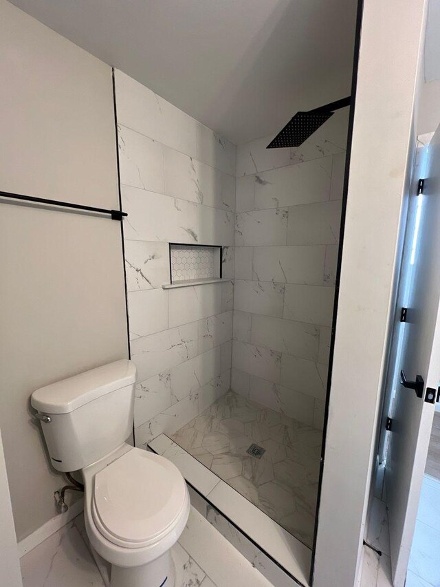 full bath with marble finish floor, a stall shower, and toilet