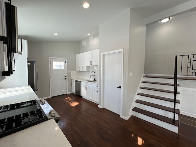 kitchen featuring a sink, light countertops, vaulted ceiling, stainless steel appliances, and dark wood-style flooring