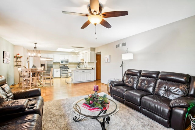 living room with ceiling fan and light wood-type flooring