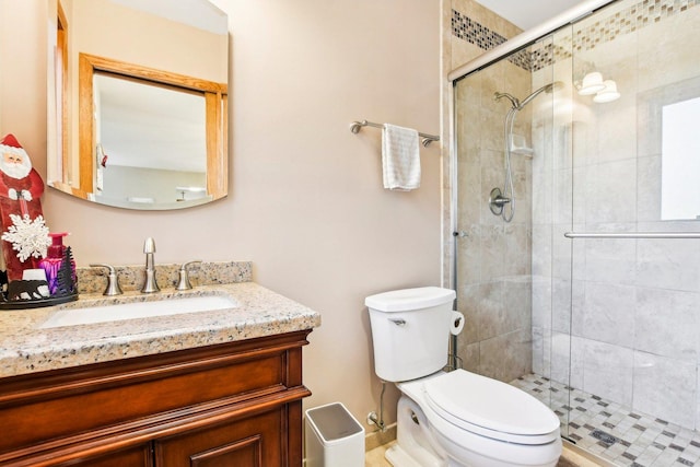 bathroom featuring vanity, an enclosed shower, and toilet