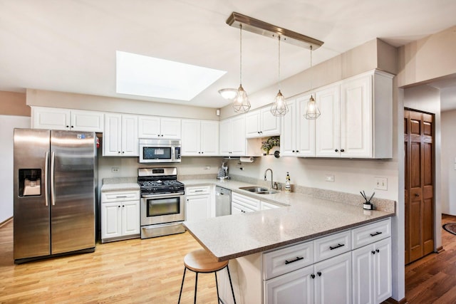 kitchen with stainless steel appliances, white cabinetry, and kitchen peninsula