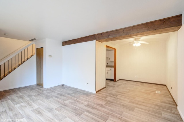 empty room with ceiling fan, beamed ceiling, and light wood-type flooring