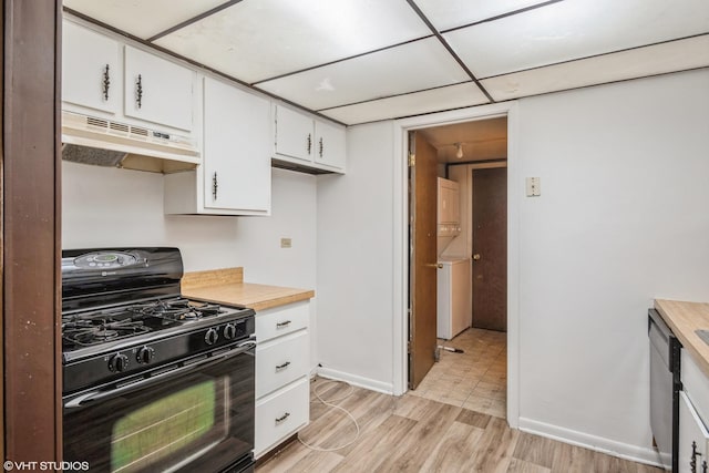 kitchen featuring white cabinetry, light hardwood / wood-style flooring, stainless steel dishwasher, stacked washer / dryer, and black gas range