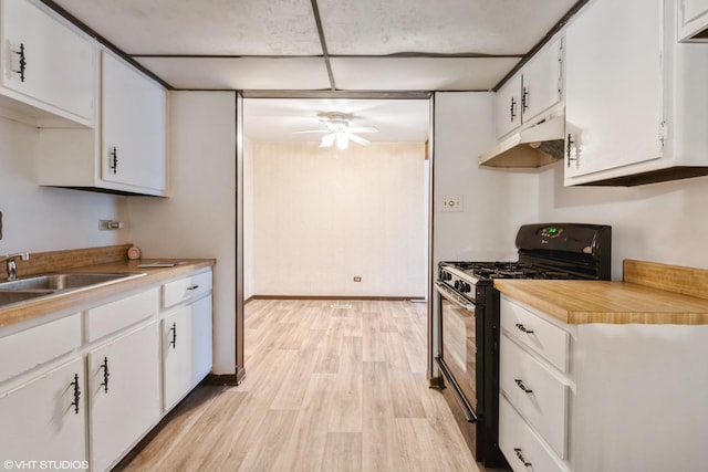 kitchen featuring black gas range oven, sink, ceiling fan, light hardwood / wood-style floors, and white cabinets