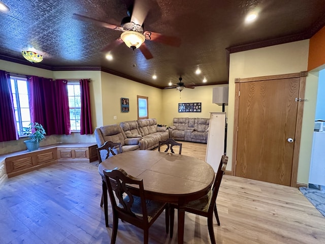 dining space with ornamental molding, ceiling fan, and light wood-type flooring