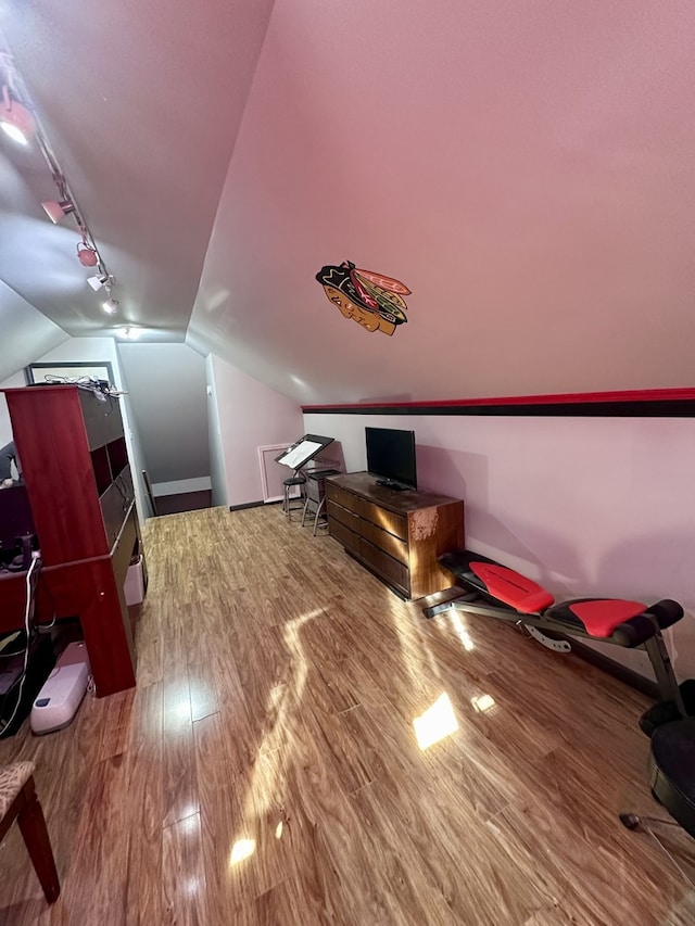 bonus room with hardwood / wood-style flooring and vaulted ceiling