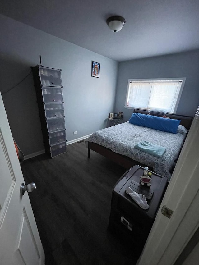 bedroom with dark hardwood / wood-style floors