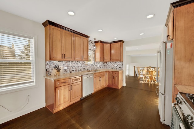 kitchen featuring white refrigerator, dishwasher, stove, and dark wood-type flooring