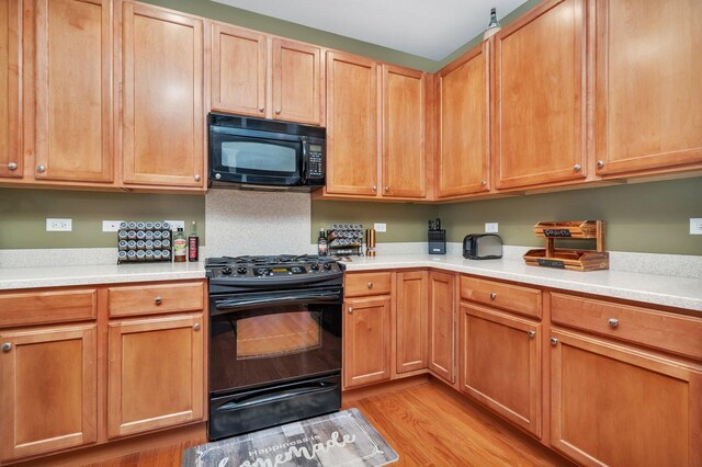 kitchen featuring light hardwood / wood-style flooring and black appliances