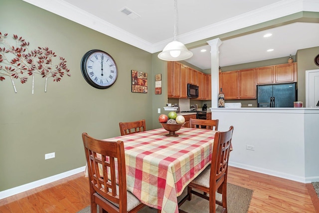 dining room with ornamental molding and light wood-type flooring