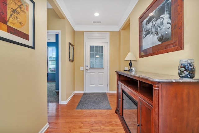 interior space with ornamental molding and light hardwood / wood-style floors