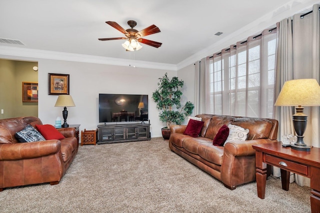 carpeted living room with ornamental molding and ceiling fan