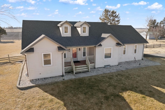 back of house featuring a lawn and covered porch