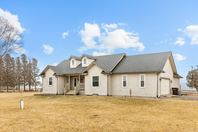 rear view of property with a garage and a yard