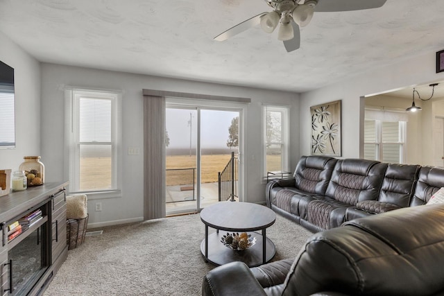 living room with a water view, carpet flooring, and ceiling fan