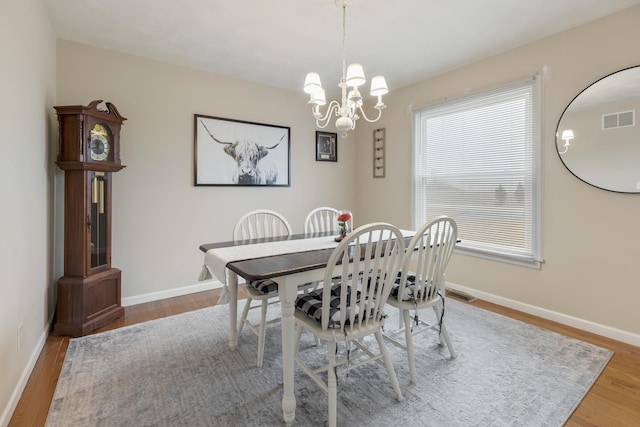 dining area featuring hardwood / wood-style floors and a notable chandelier