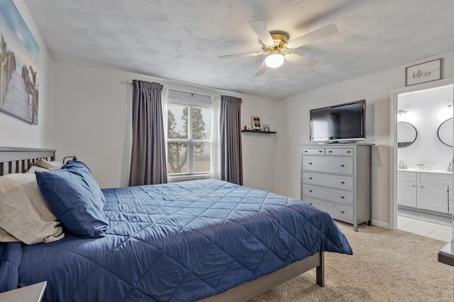 carpeted bedroom featuring ceiling fan and ensuite bath