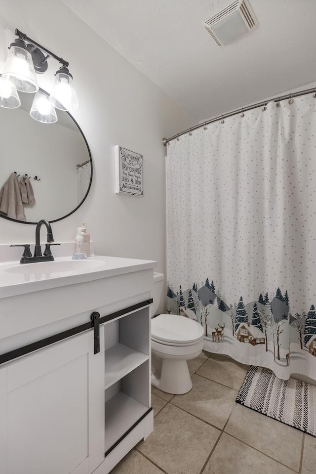 bathroom with tile patterned flooring, vanity, and toilet