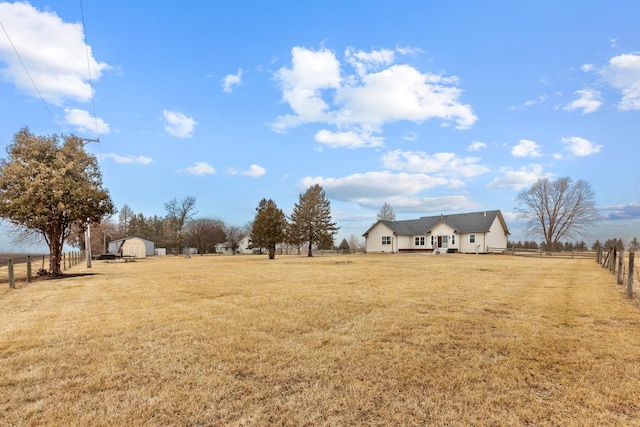 view of yard with a rural view and a storage unit