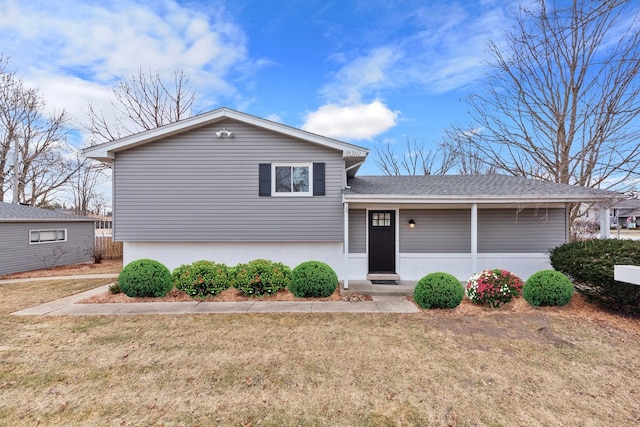 tri-level home featuring a front yard and roof with shingles