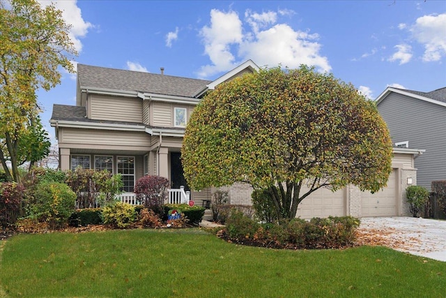 view of front of home featuring a garage, covered porch, and a front yard